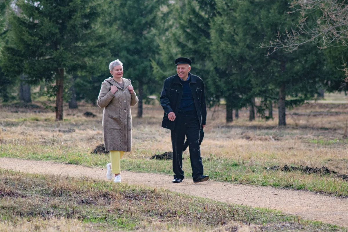 Couple de seniors se promenant sur un chemin de parc par une belle journée